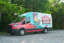 A Tennessee Standard Plumbing & Drain service van is parked outdoors, showcasing company branding, a cartoon plumber, and TNStandard.com—ready to tackle issues like repeated drain clogs.