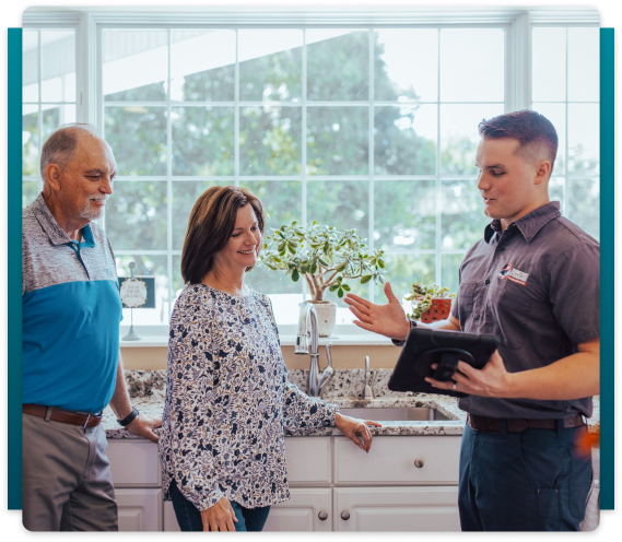 plumber talking to elder couple in the kitchen